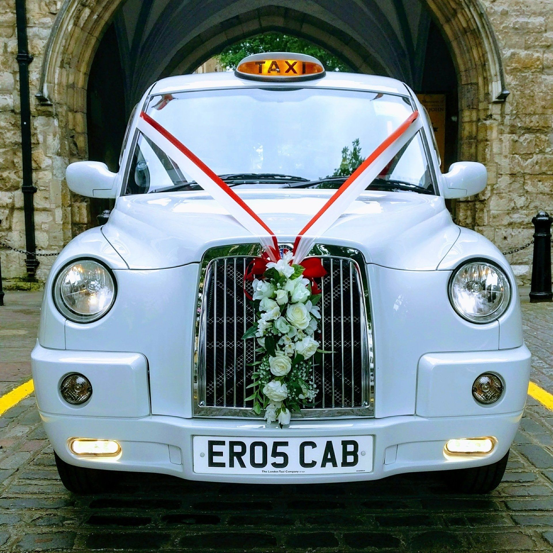 White Wedding Taxi with Red & White Wedding Ribbons