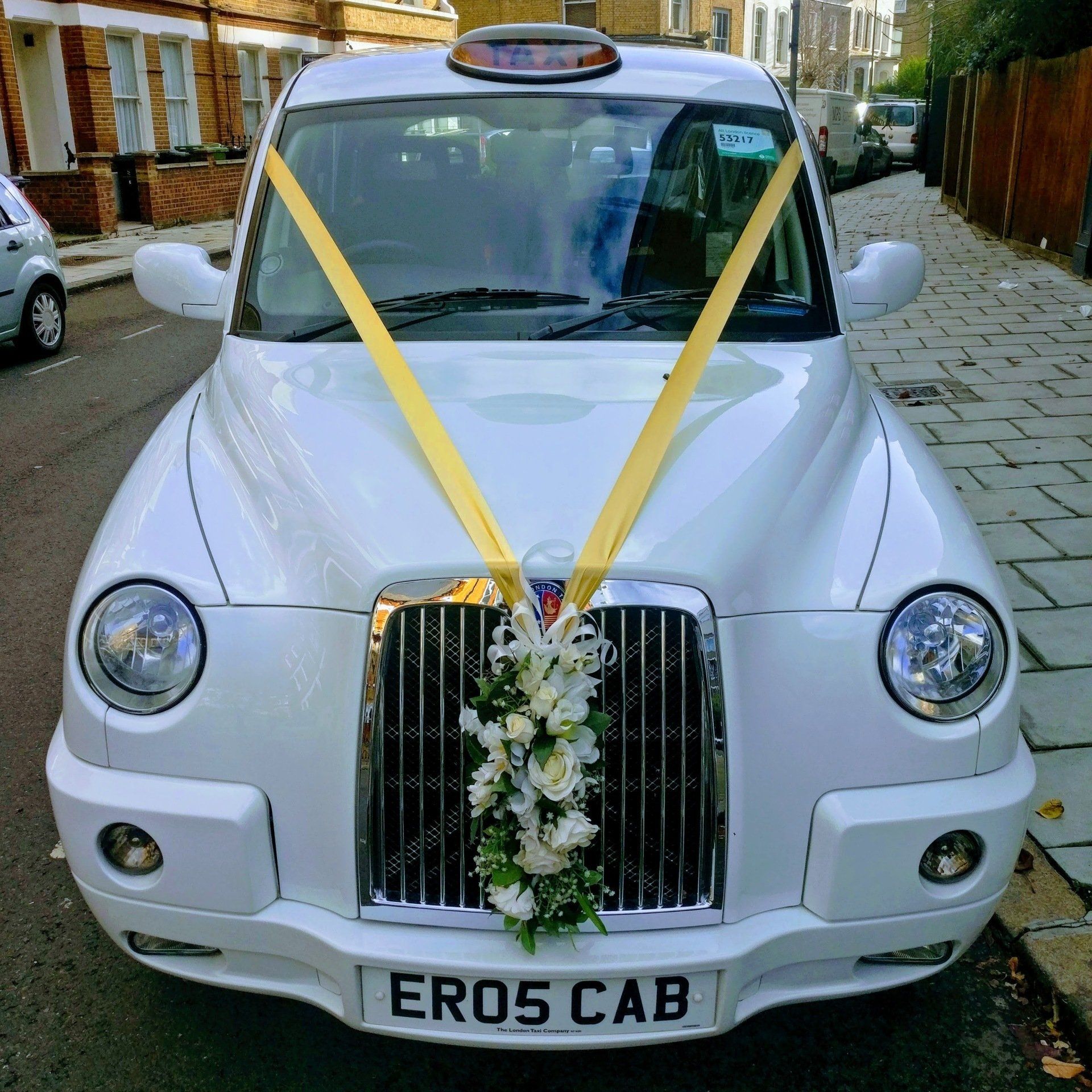 White Wedding Taxi with Gold Wedding Ribbon
