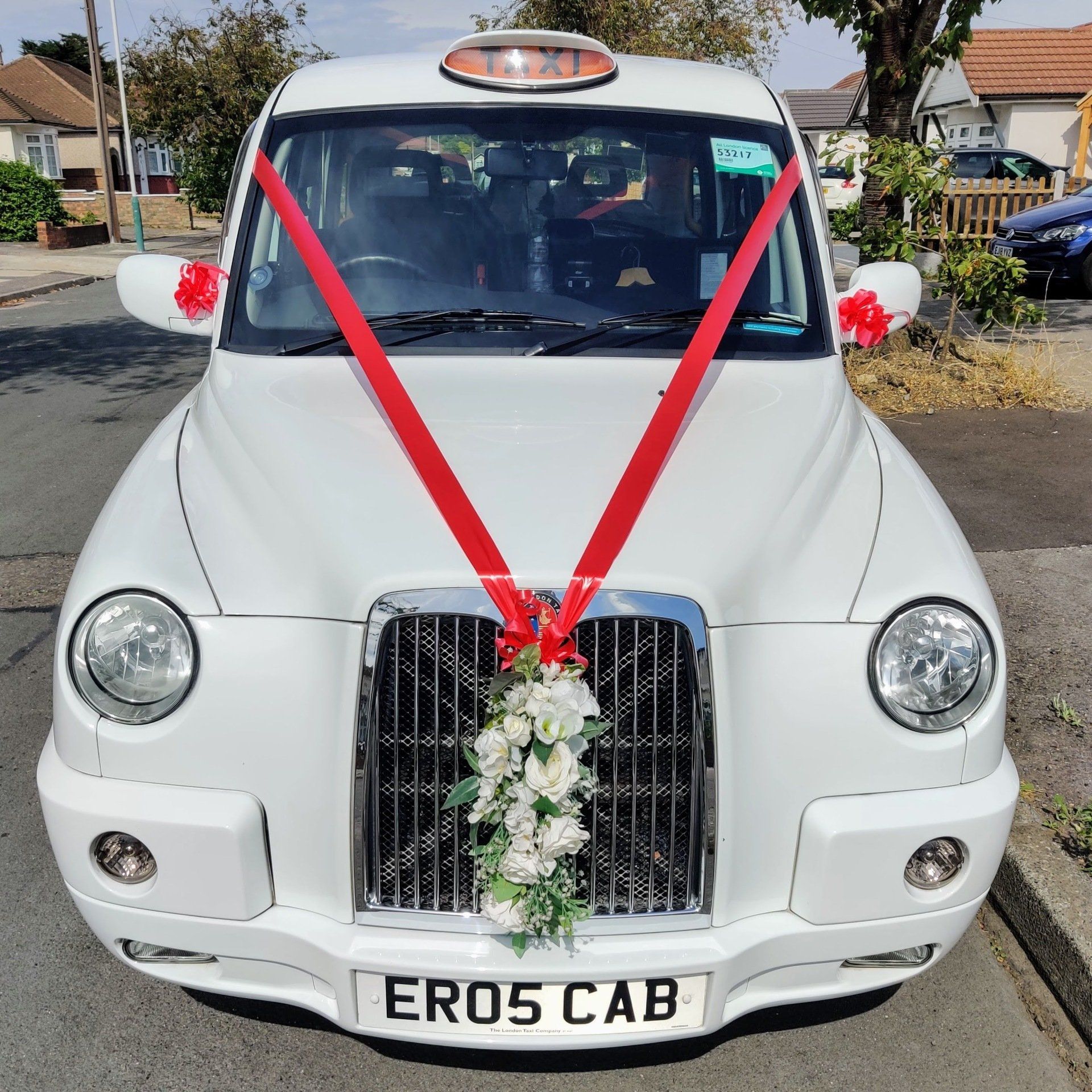 White Wedding Taxi with Bright Red Wedding Ribbon