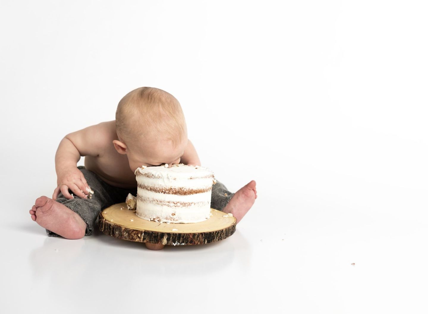 Baby with head in Buttercream Smash Cake