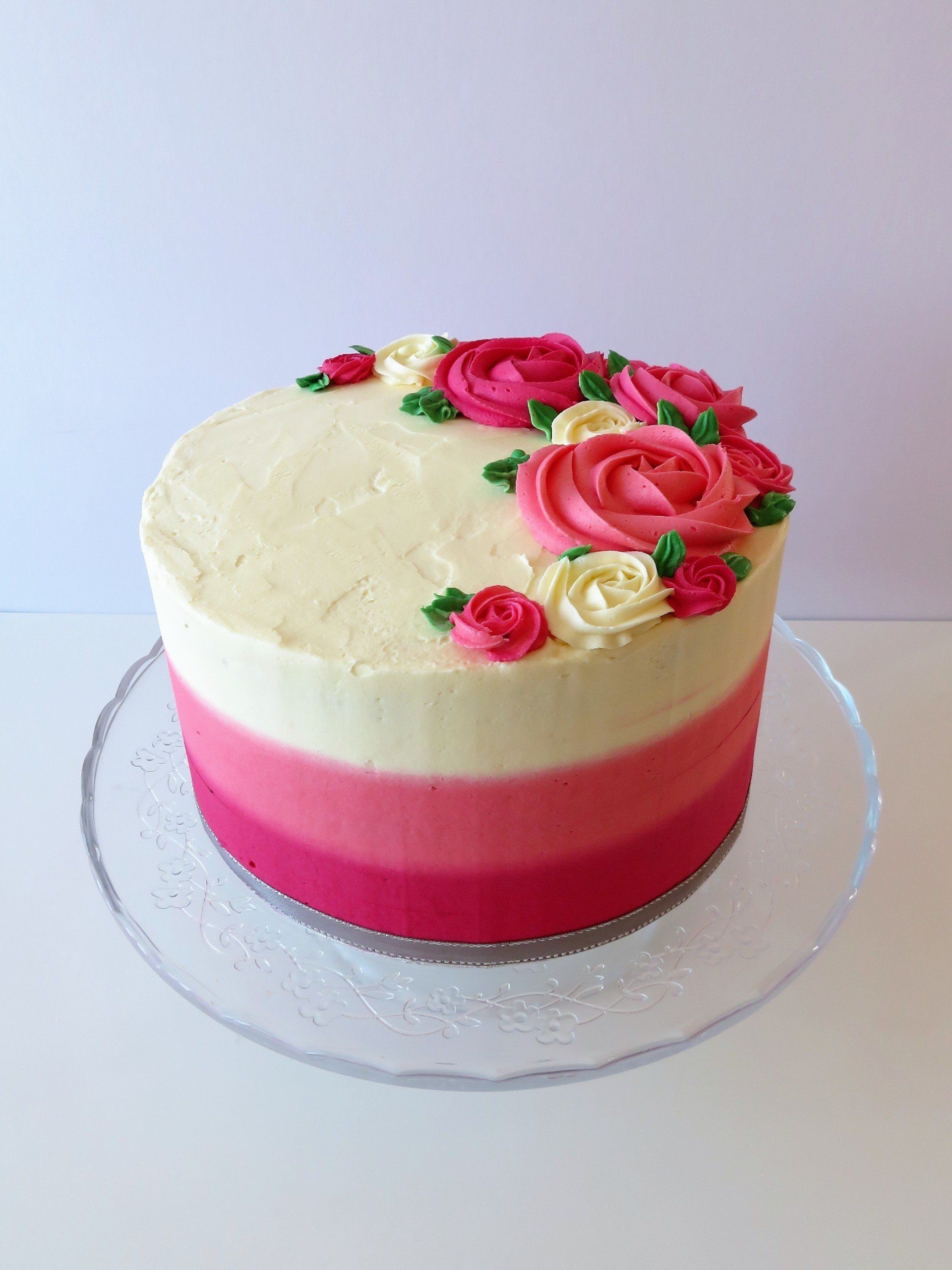 Pink and cream cake topped with buttercream roses