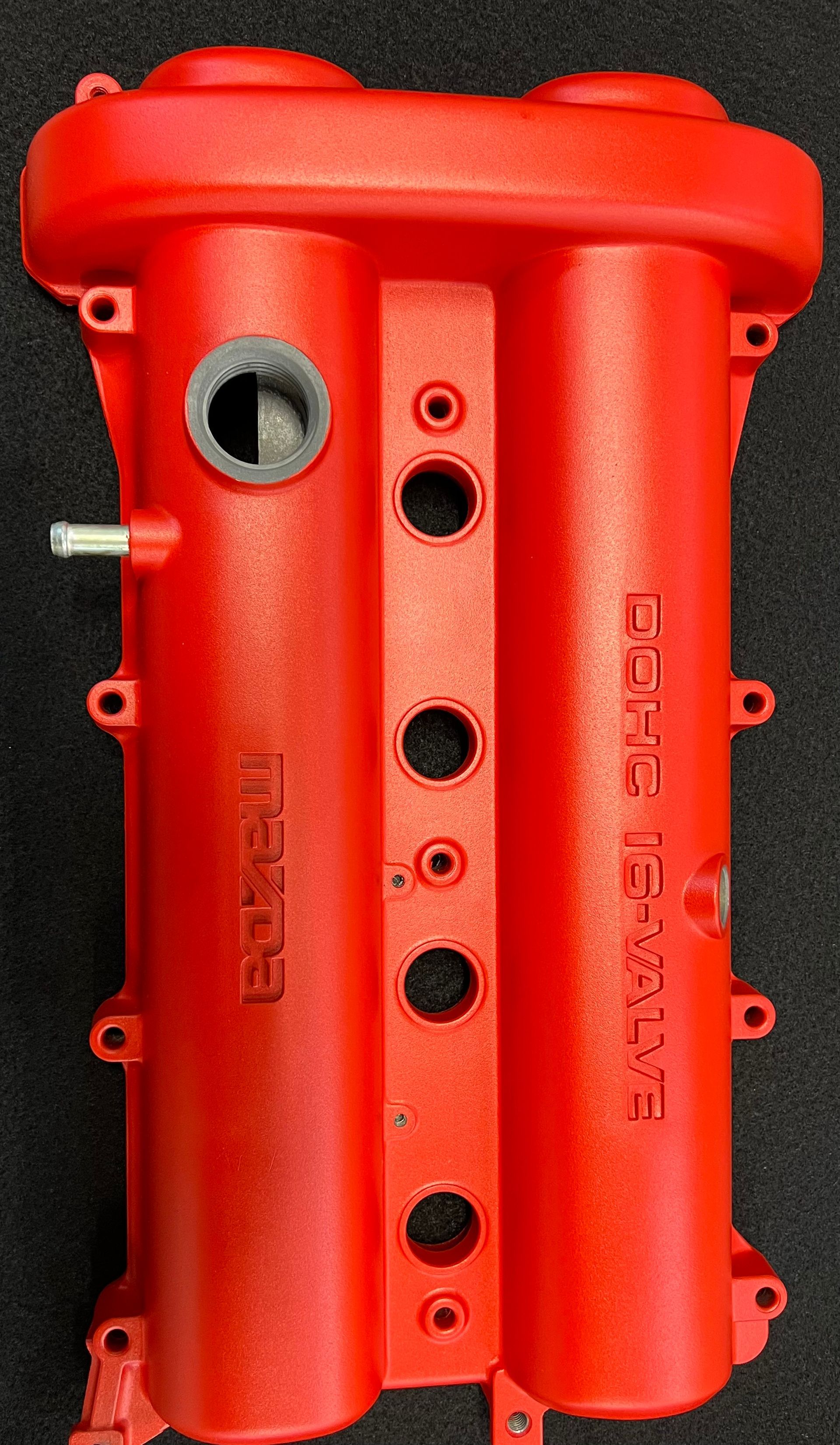 a red metal object with holes