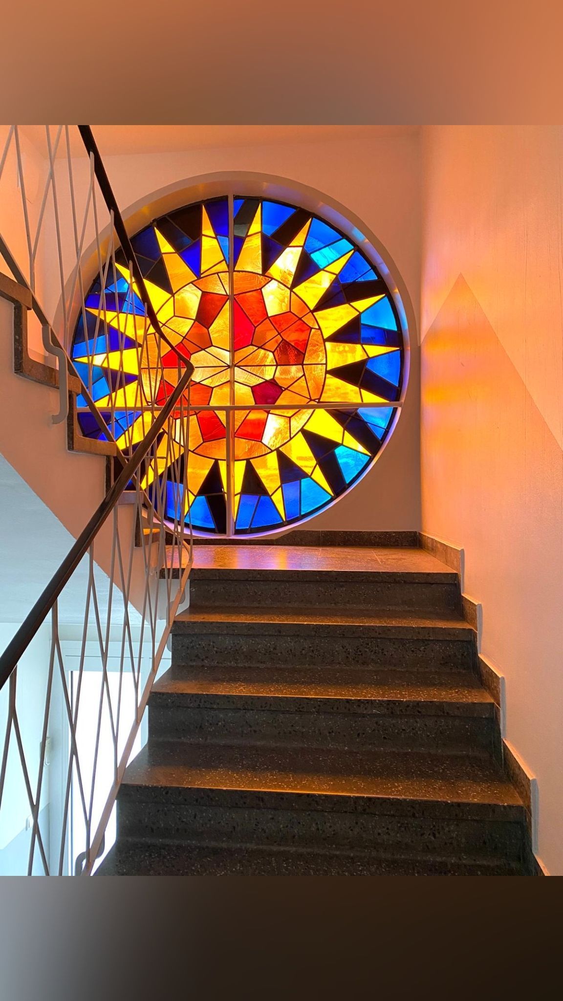 Rundes großes Treppenhausfenster. Buntglas. Sonne. 