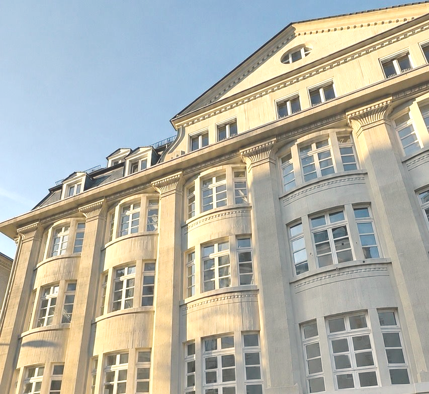 Herrschaftliche Altbau Fassade. Beige. Säulen. Verzierungen. Weiße Sprossen Fenster. Gauben. Schiefer. Spitzer Giebel.