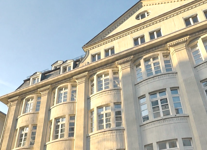 Herrschaftliche Altbau Fassade. Beige. Säulen. Verzierungen. Weiße Sprossen Fenster. Gauben. Schiefer. Spitzer Giebel.