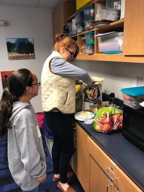 Student and volunteer preparing snacks