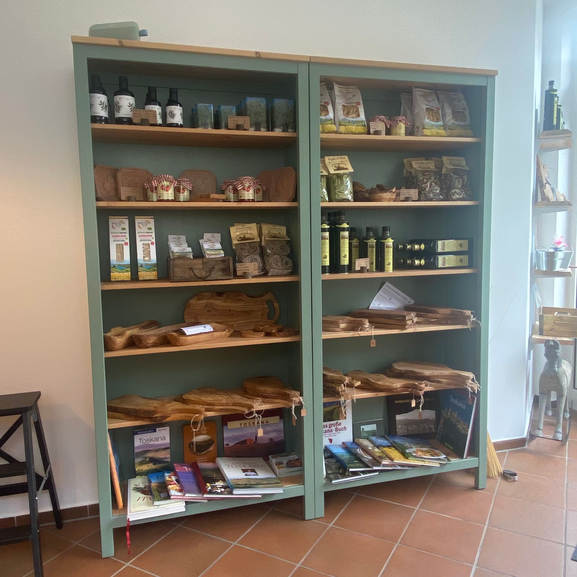 Verkaufsregal von Tesori d´Olivo bestückt mit Olivenöl, Pastaverpackungen, Olivenholzprodukte und verschiedenen Pastasoßen