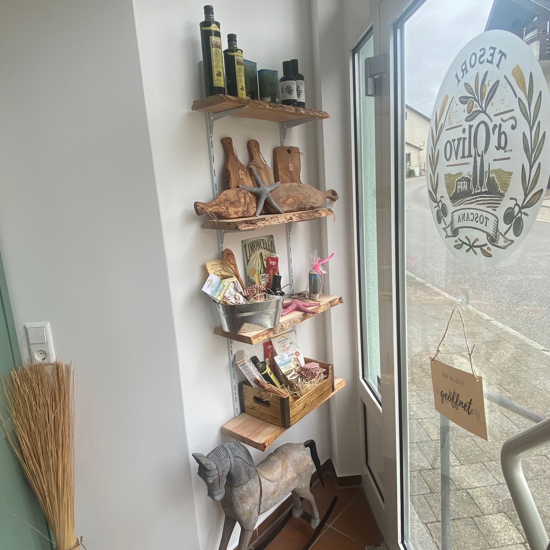 Regalsystem von Tesori d´Olivo, auf dem Olivenöl, Olivenholzbretter und verschiedene Geschenkarrangements präsentiert sind