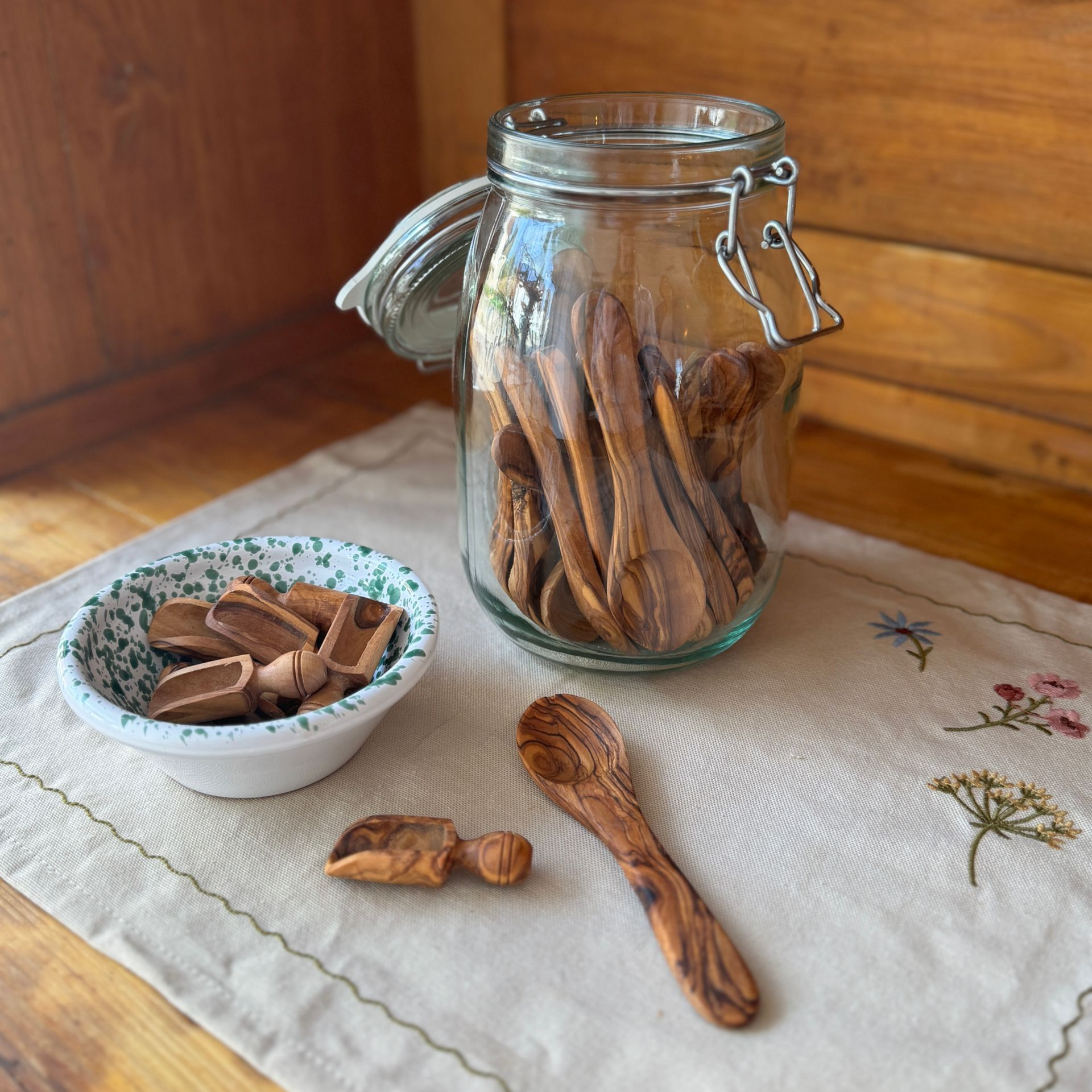 großes Einmachglas gefüllt mit zahlreichen Teelöffeln aus Olivenholz und ein kleines Schälchen mit Dosierschäuffelchen