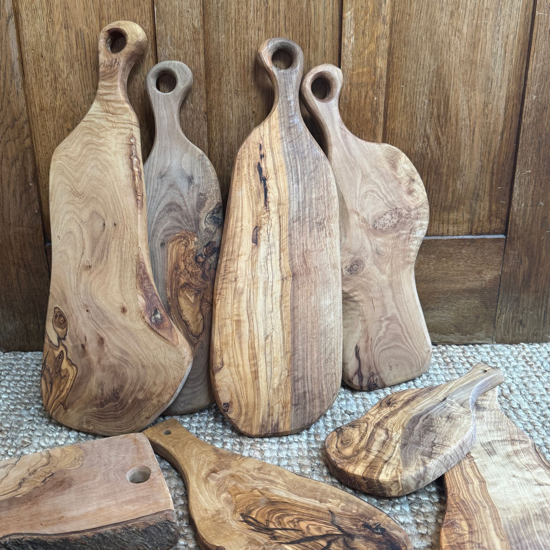 verschiedene Größen und Forman von Olivenholzbretter teilweise angelehnt an eine Holzrückwand und teilweise auf dem Boden 