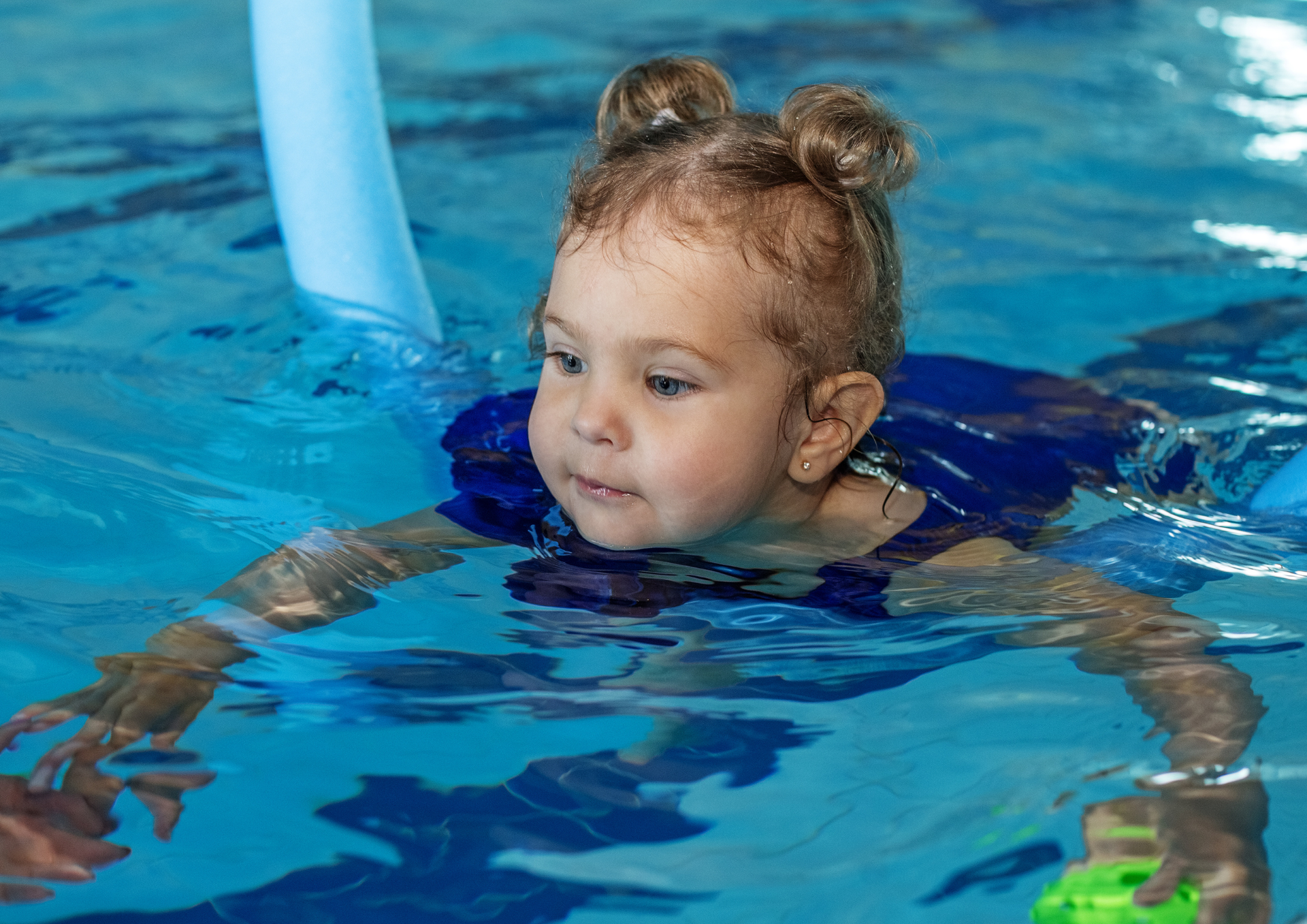 Mädchen schwimmt mit Schwimmbrett