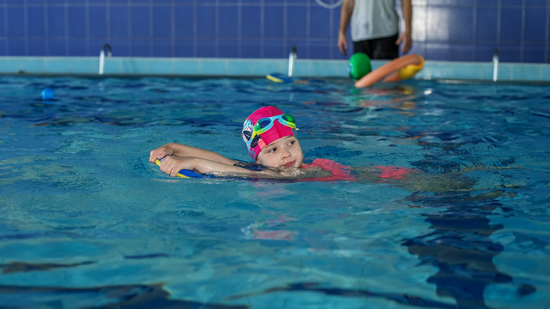 Mädchen schwimmt mit Schwimmbrett