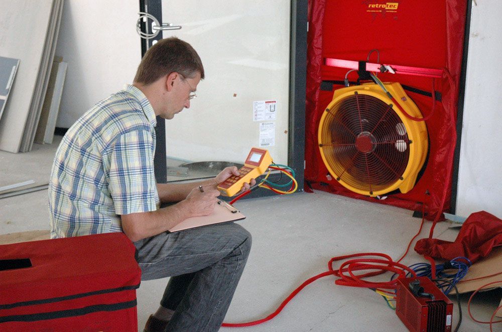 Bausachverständiger führt ein Blower Door Test durch Bausachverständiger führt ein Blower Door Test durch