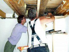 Bausachverständiger und Handwerker arbeiten an einer Gebäudedecke