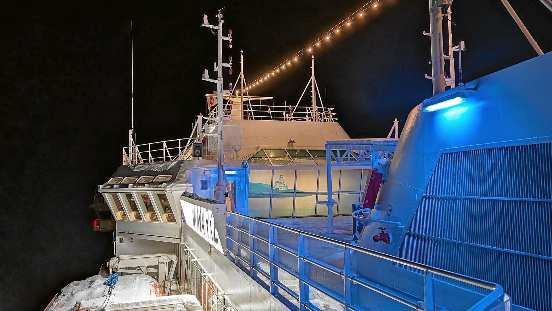Schiffsdeck bei Nacht, weiß mit blauen Lichtern, beleuchtet mit Lichterketten.