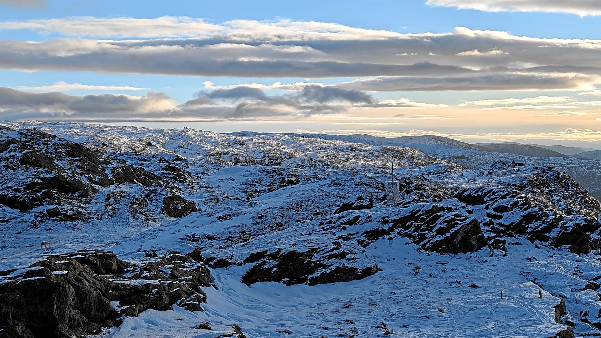Schneebedeckte Felsgebirgskette unter bewölktem Himmel.