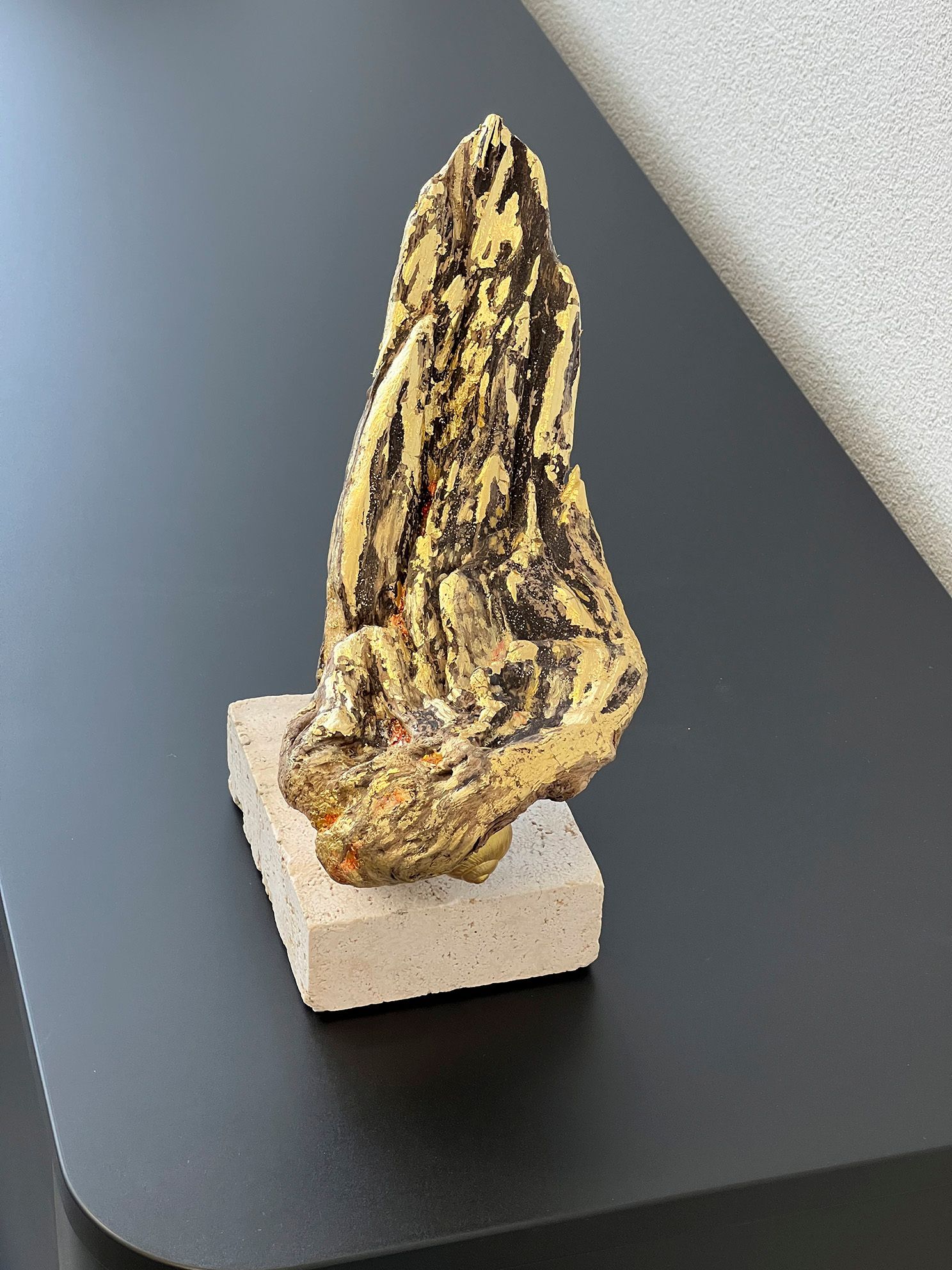 Feuerhand, mit Blattmetallvergoldung auf Travertin