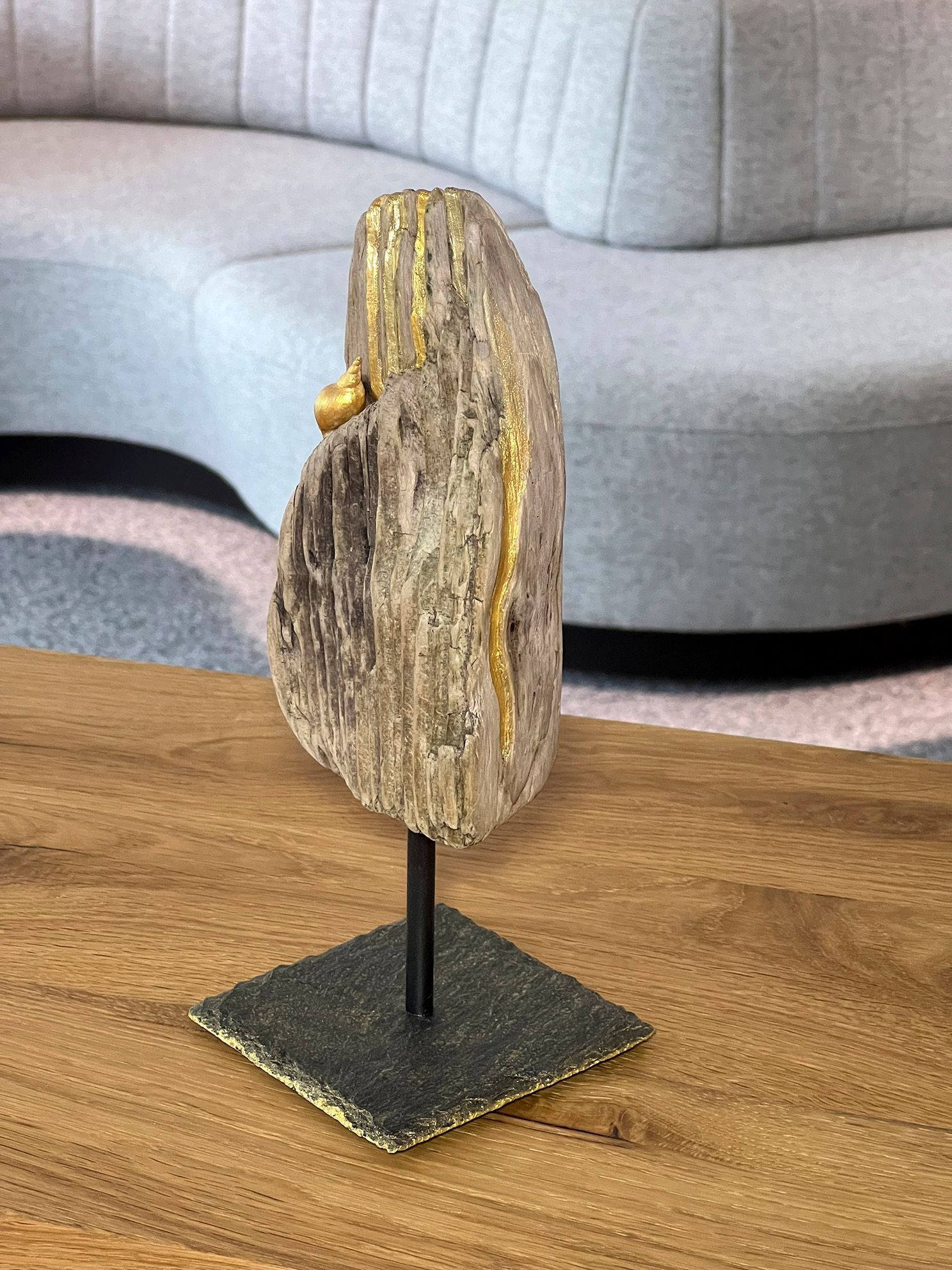 Holzstruktur mit Goldspuren und Seeschnecke