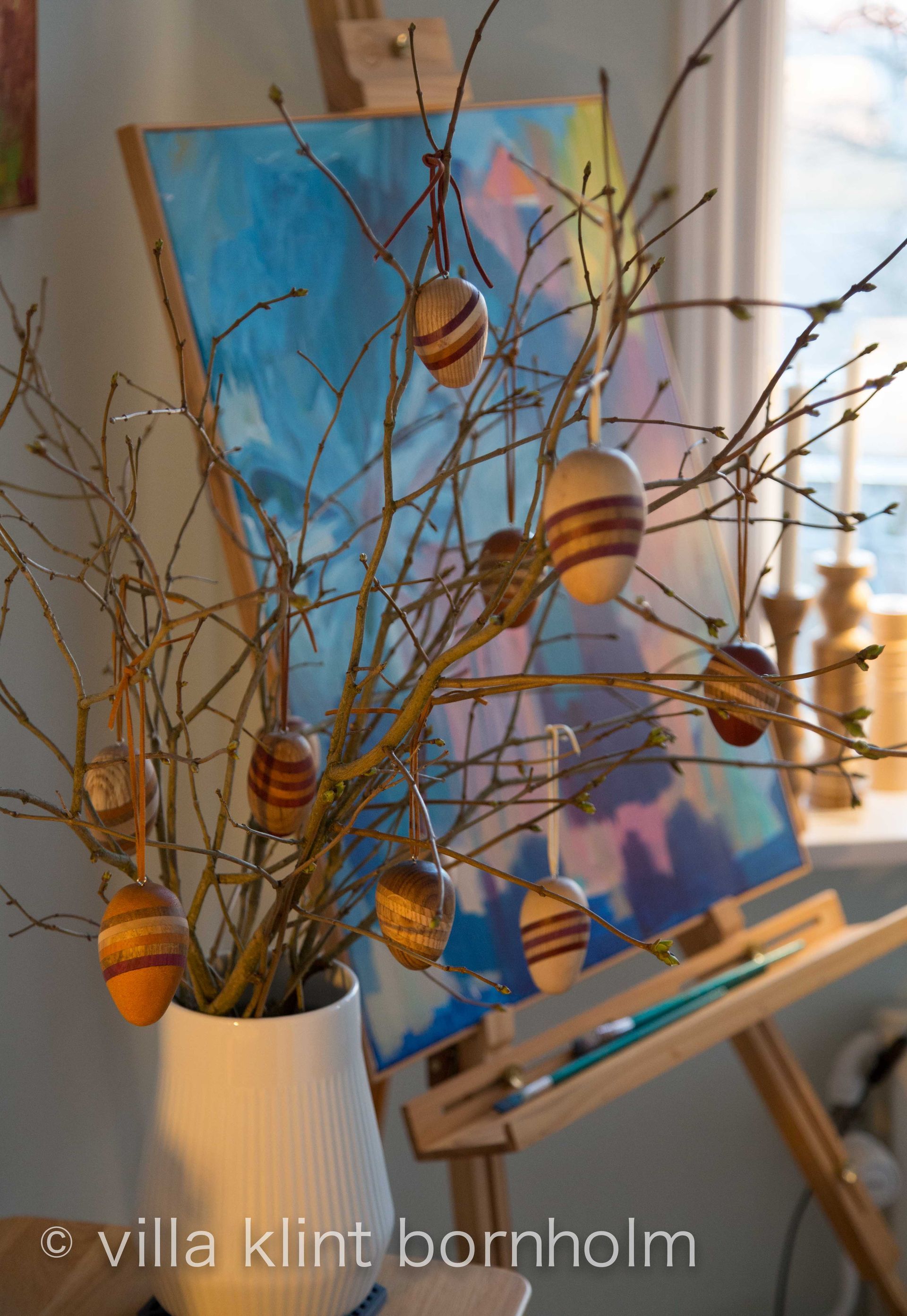 Osterimpression; Bild mit davor am Busch hängenden Pstereiern