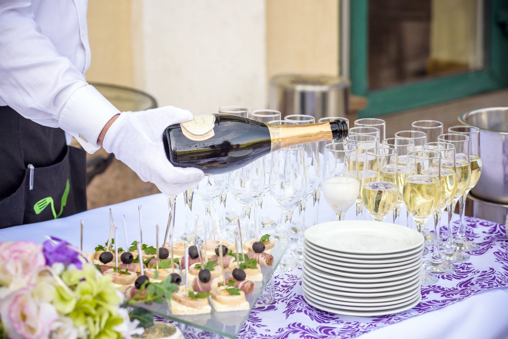 Réceptions & vous - Serveur servant du champagne dans des flûtes à champagne