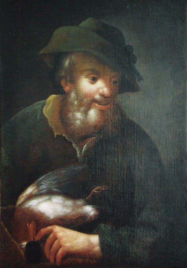 Mann in grünem Mantel und Hut, der einen dunklen Vogel hält, lächelt.