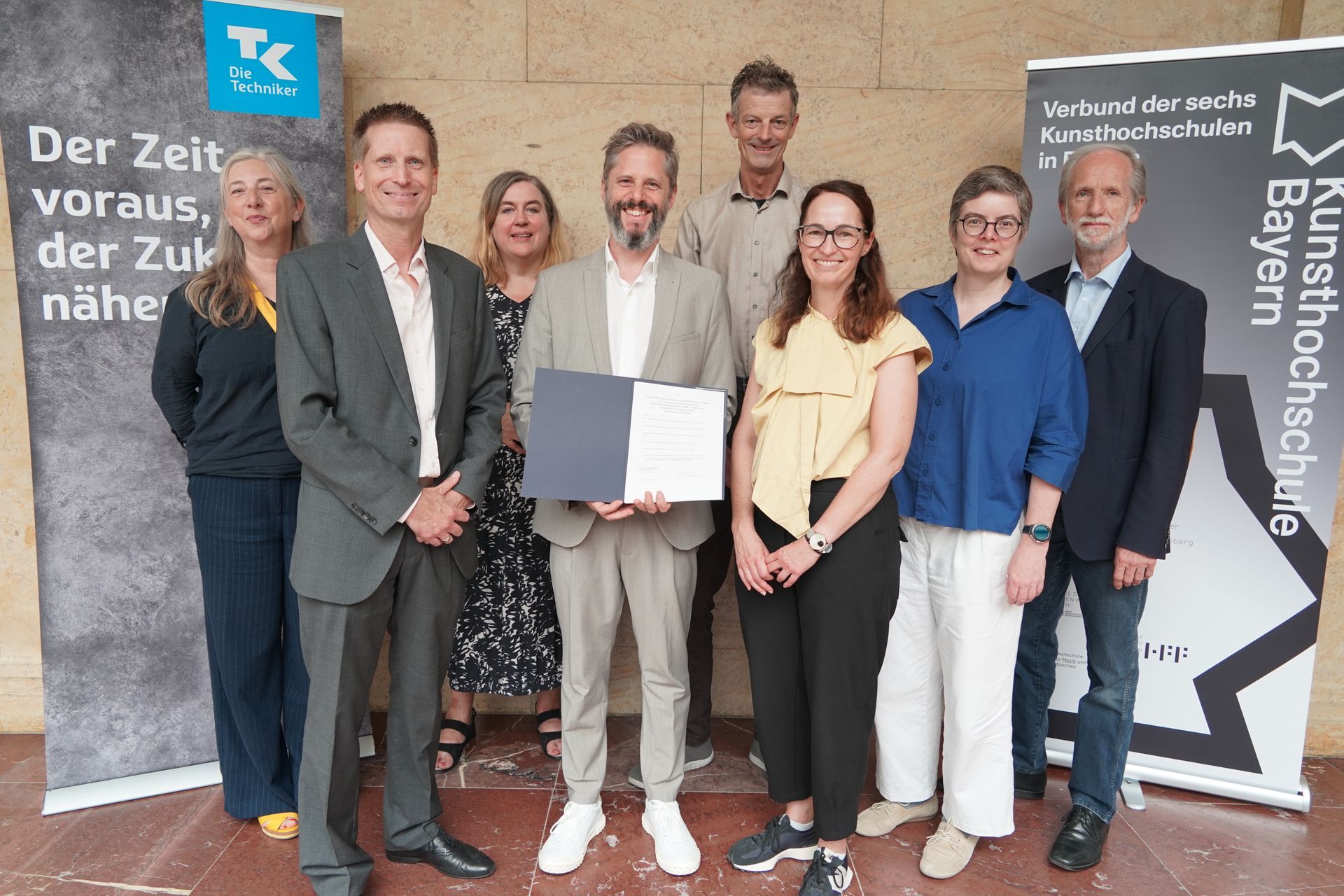 Foto: Hochschule für Musik und Theater München
Von links: Prof. Eva von Platen-Hallermund (Präsidentin der AdBK Nürnberg), Dirk Helfrich, (Techniker Krankenkasse, Leiter Hochschulteam Bayern), Prof. Karen Pontoppidan (Präsidentin AdBK München), Prof. Rainer Kotzian (Präsident HfM Nürnberg), Daniel Sponsel (Präsident HFF), Nicole Gröger (Techniker Krankenkasse, Beraterin für Hochschulisches Gesundheitsmanagement), Prof. Lydia Grün (Präsidentin HMTM), Prof. Dr. Christoph Wünsch (Präsident HfM Würzburg)
