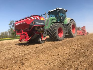 Fendt-Traktor mit angebauter Horsch-Drillmaschine beim Arbeiten an einem sonnigen Tag.