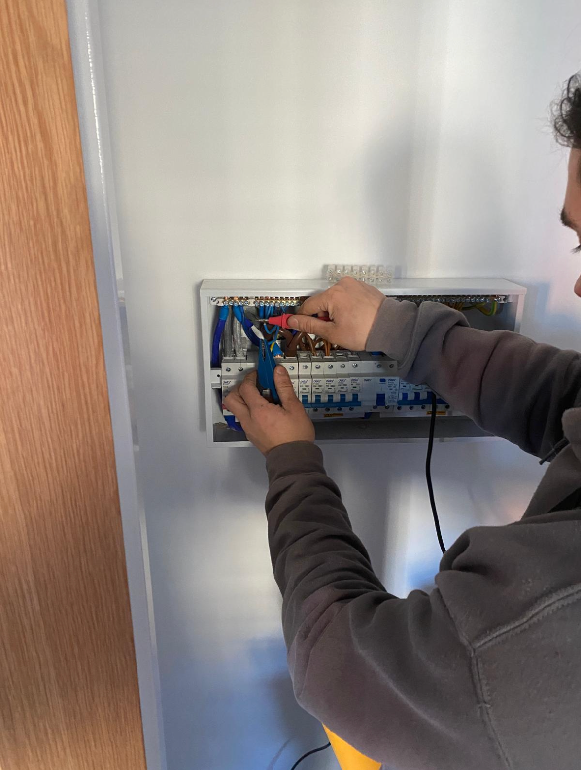 Electrician inspecting and testing a distribution board