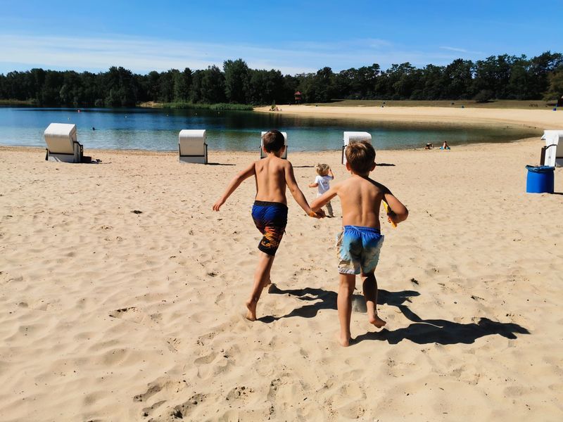 Badegäste und Sonnenschirme am Heidesee
