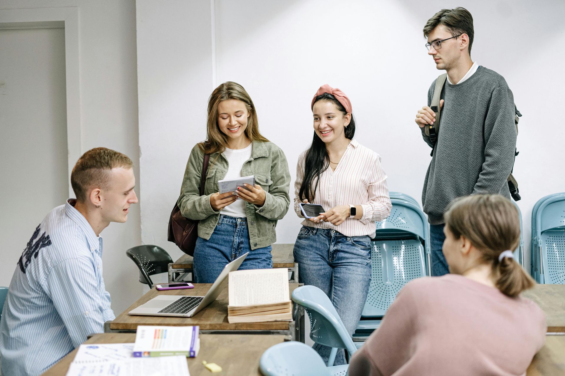 Gruppe junger Leute lernt gemeinsam mit Laptop und Büchern
