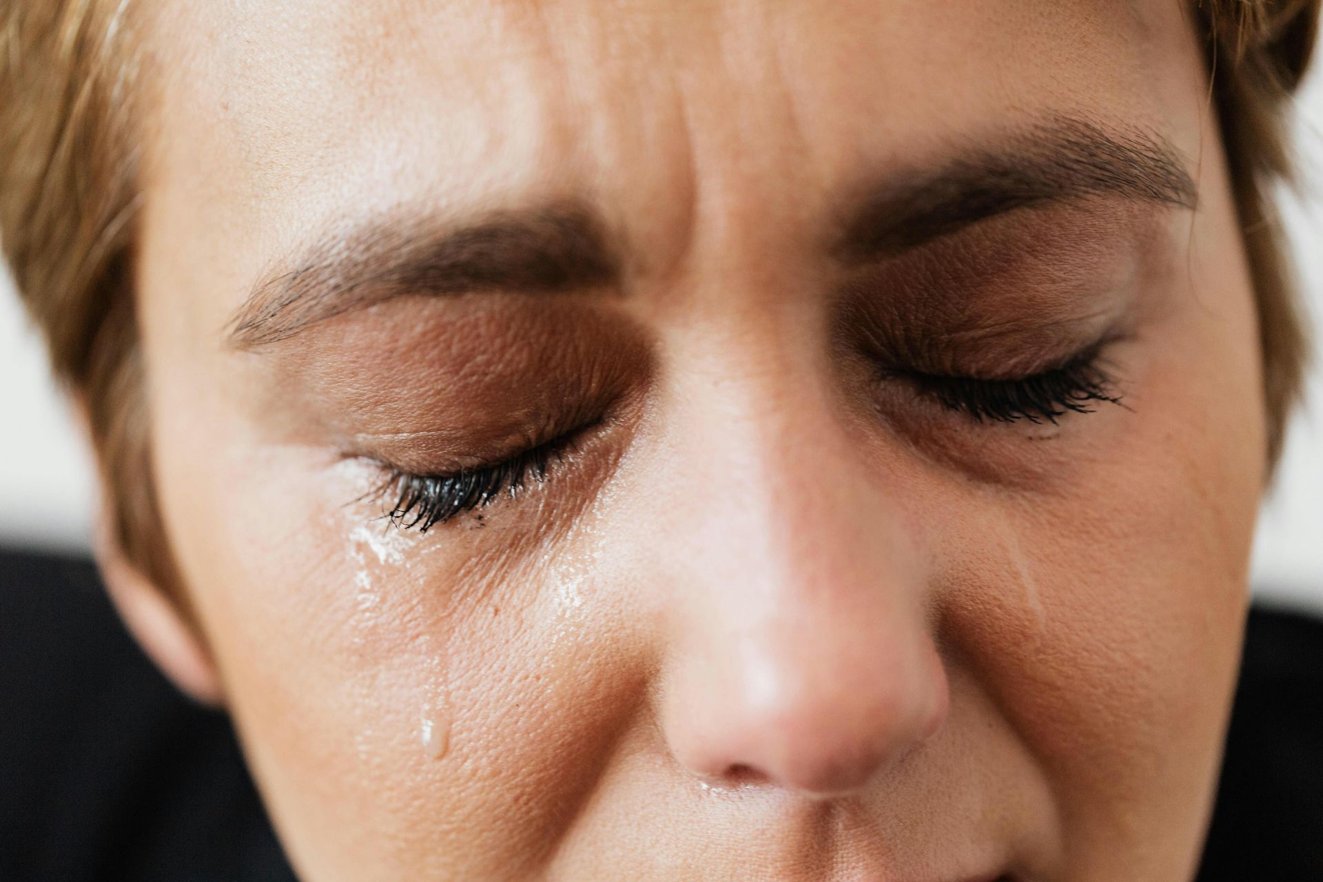 Frau mit geschlossenen Augen weint still und bewegt