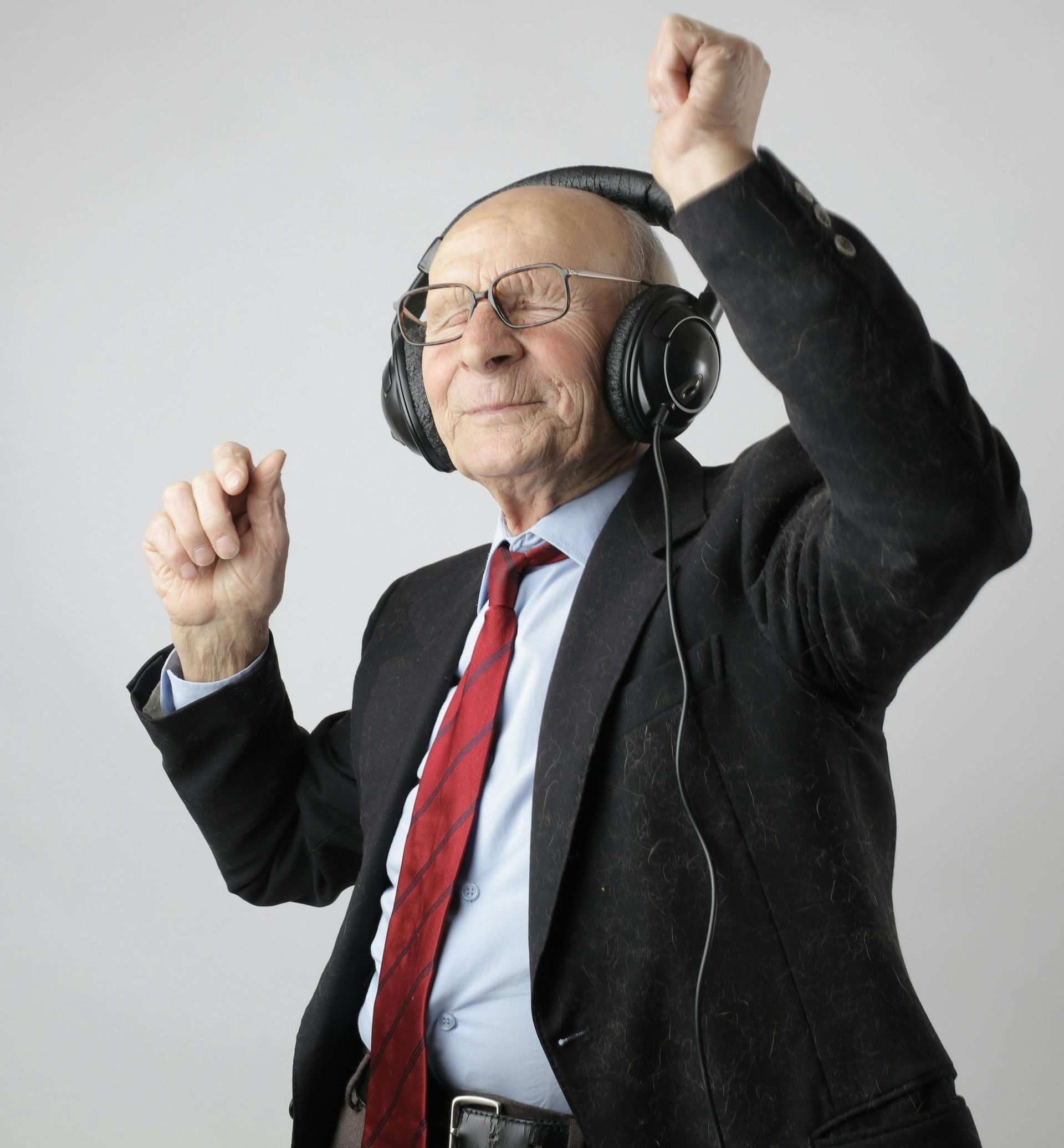 Älterer Mann mit Kopfhörern tanzt genießend zur Musik