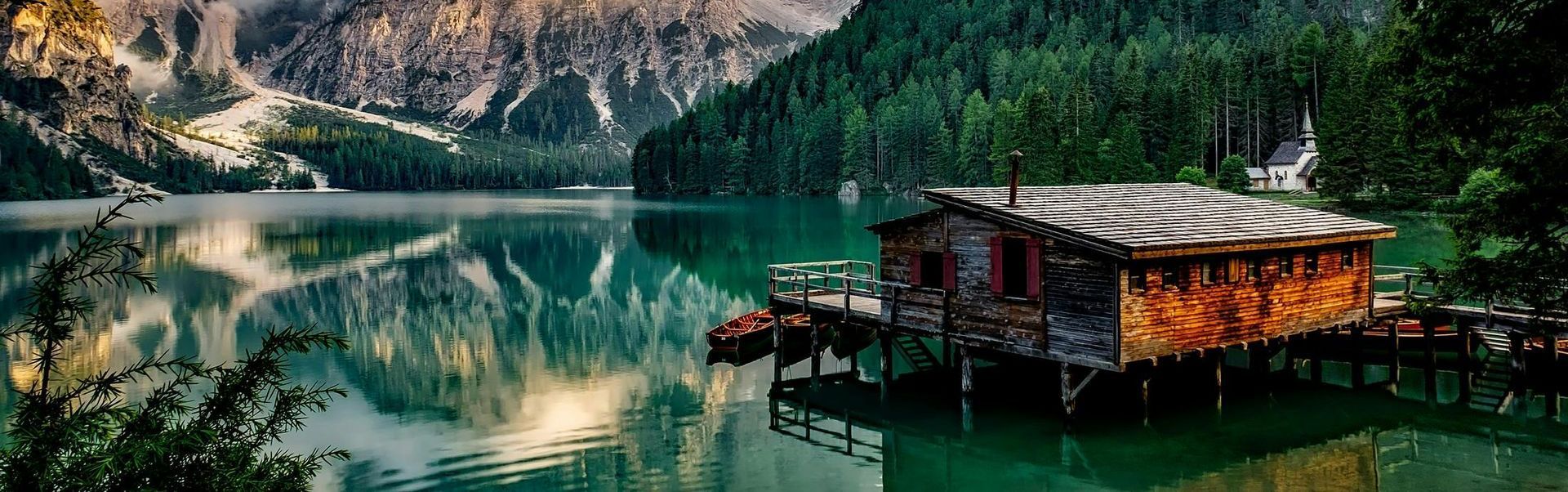 Holzhütte am See mit Bergblick und Waldspiegelung