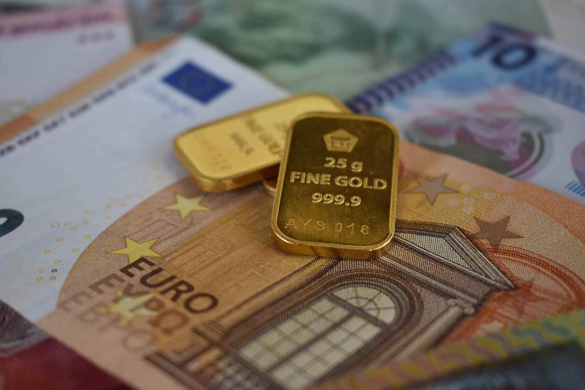 Zwei kleine Goldbarren auf verschiedenen Euro-Banknoten
