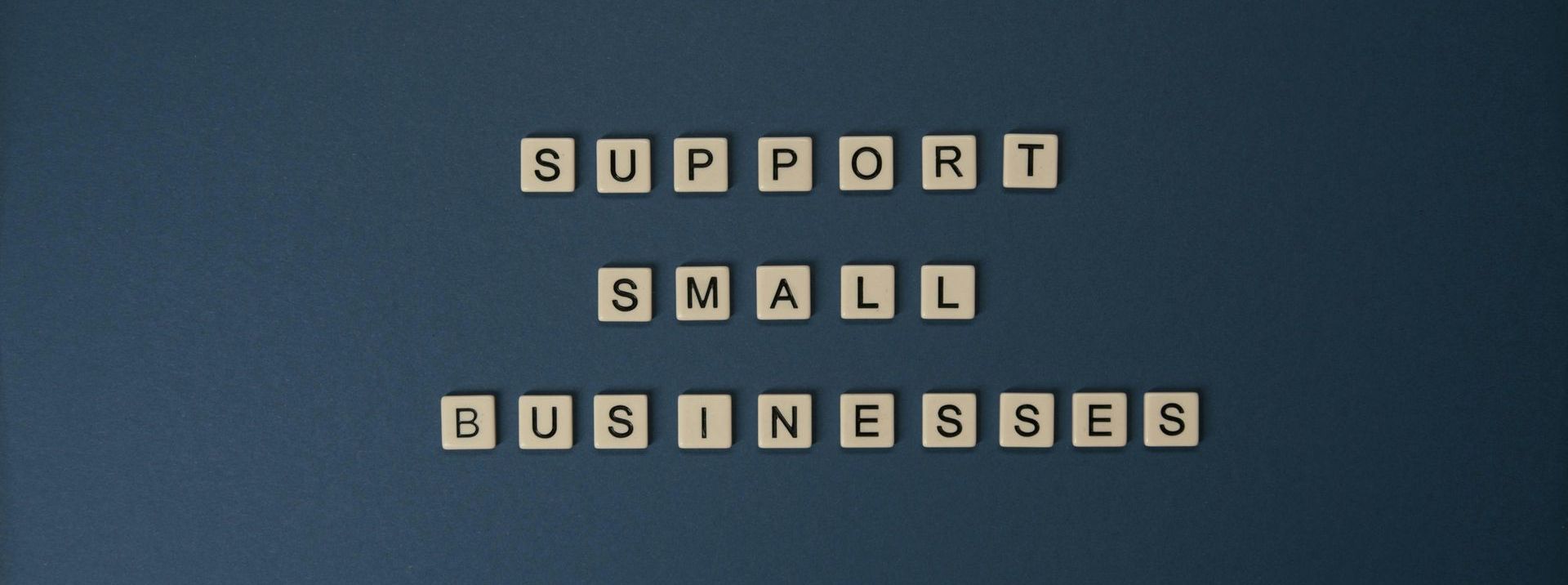 Buchstabenplättchen formen den Satz „Support Small Businesses“