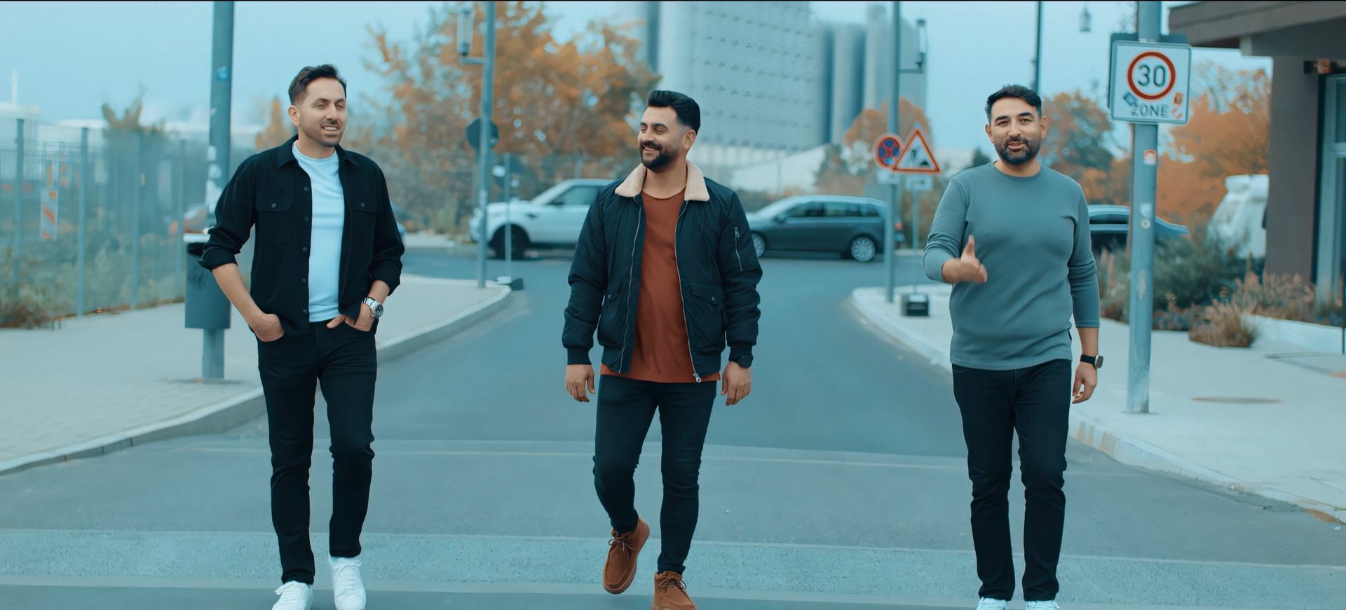 Grup 12 üyeleri, klip çekimi sırasında sokakta yürüyerek enerjik ve samimi bir sahne sergiliyor.