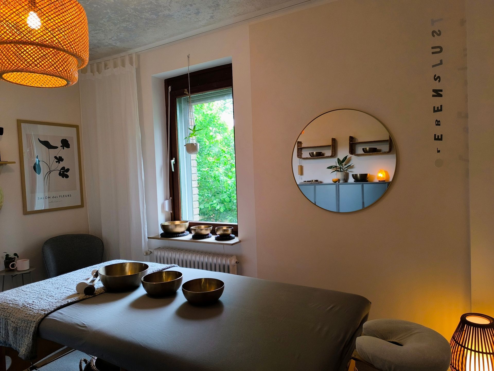 Der Klangraum im Atelier Samenkorn. Das Bild zeigt einer Massageliege, auf der sich drei Klangschalen befinden. 