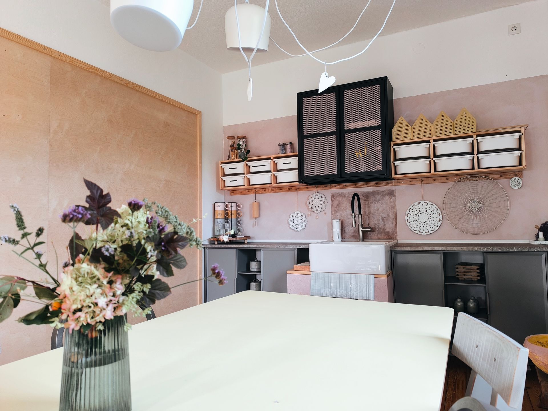 Ein Kreativraum, mit Regalen an der Wand, frischer großer Blumenstrauß im Vordergrund