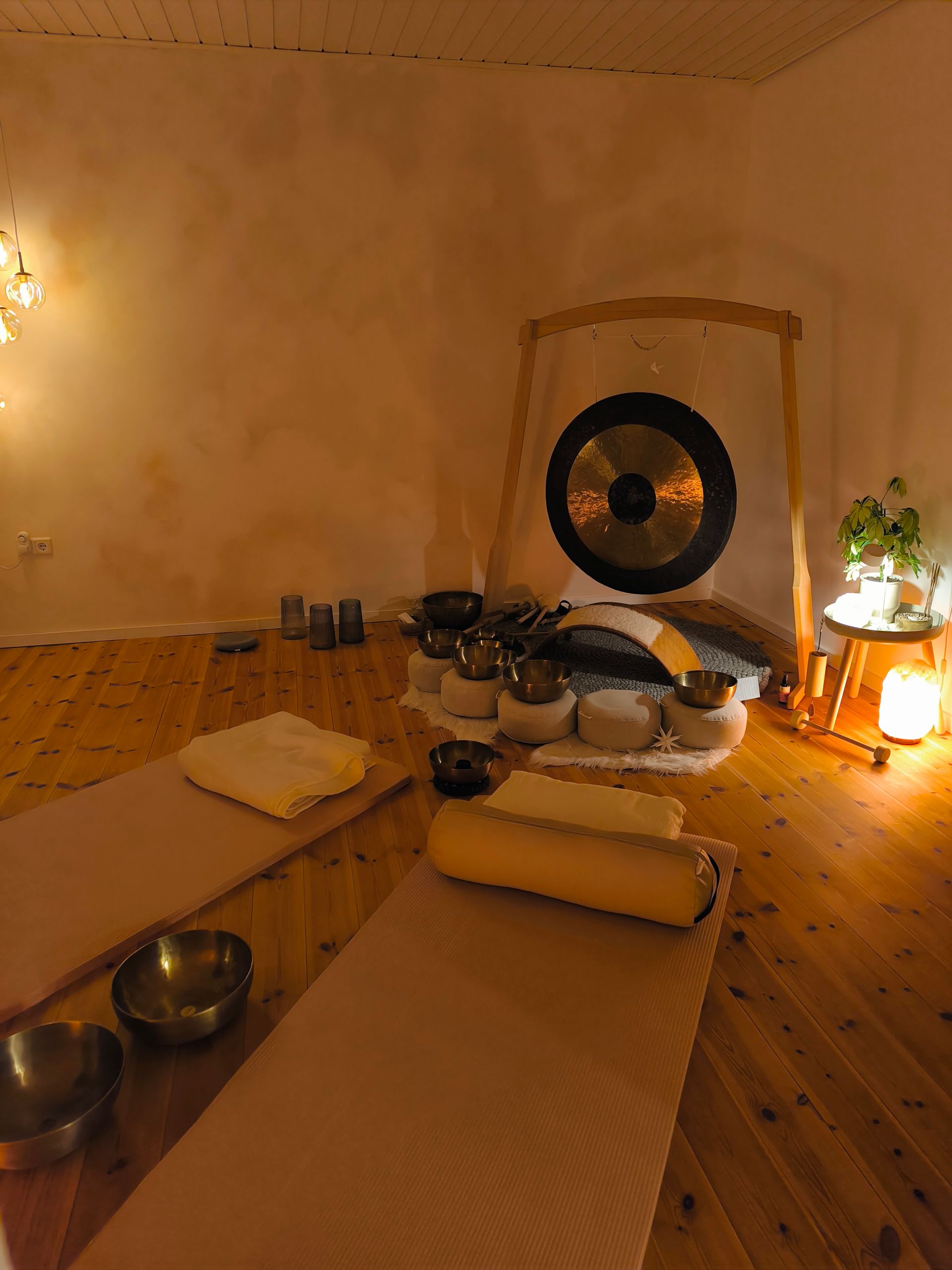 Entspannungsraum im Atelier Samenkorn, ein großer Gong mit Yogamatten davor und vielen Klangschalen