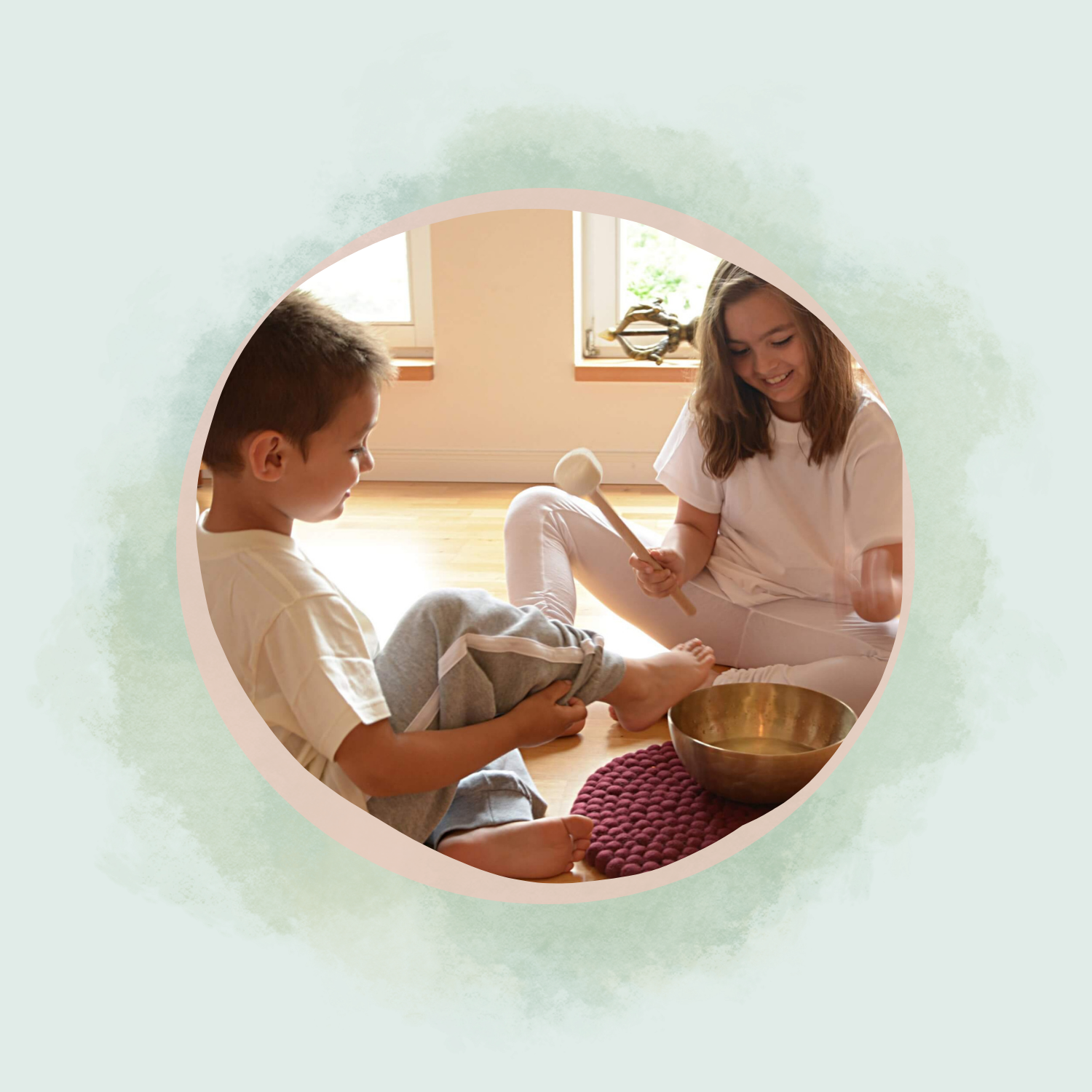 Zwei Kinder schlegeln eine Klangschale an