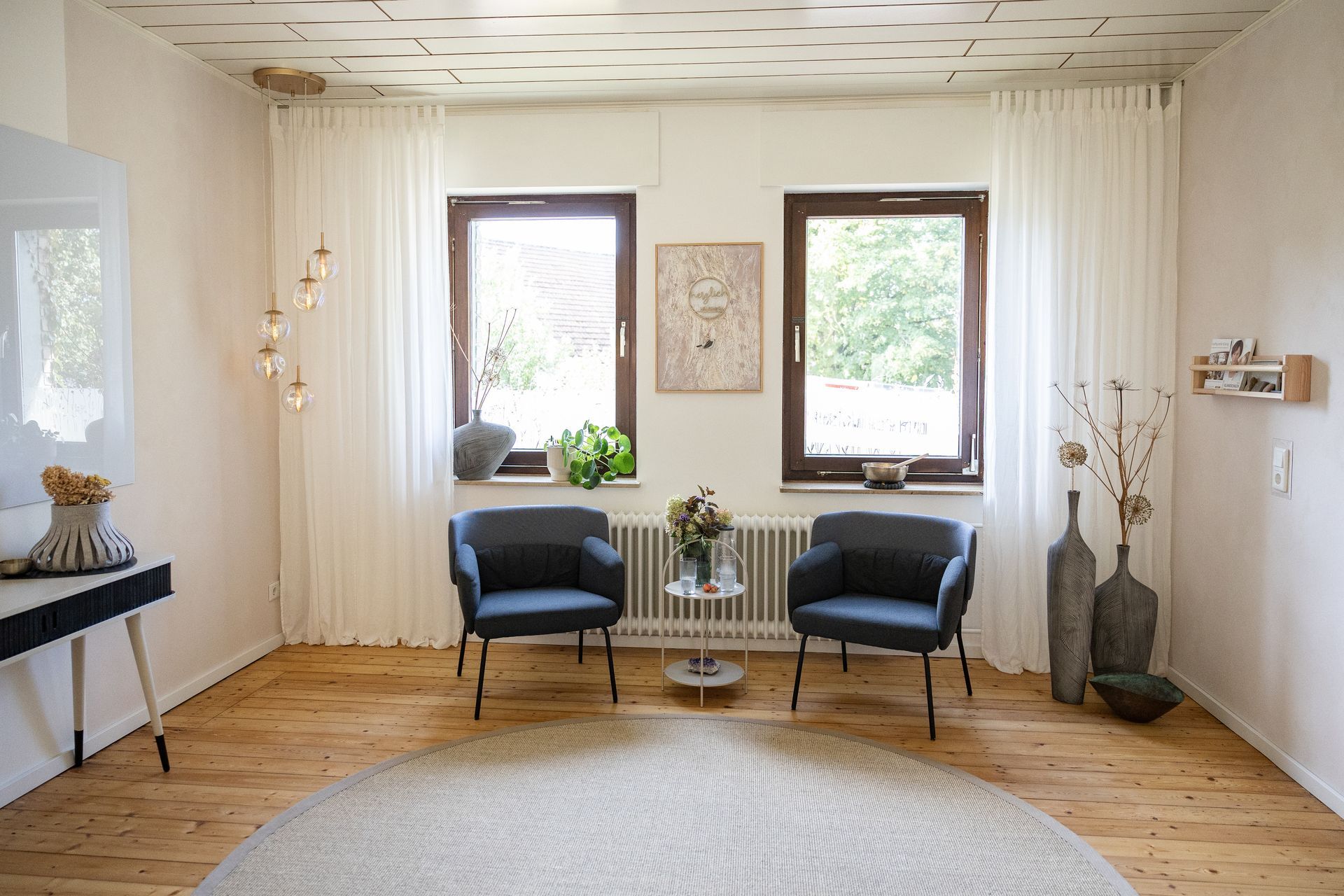 Seminarraum des Ateliers Samenkorn. Zwei Polsterstühle stehen vor zwei Fenstern.