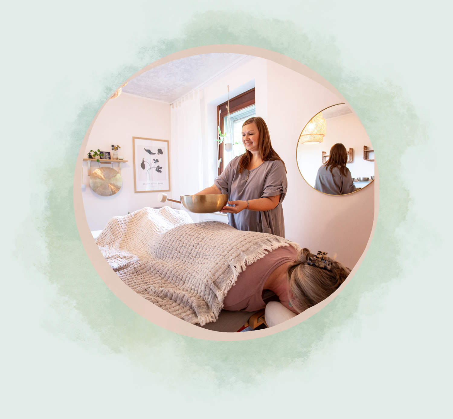 Julia Pantou gibt eine Klangmassage. Eine zweite Frau liegt auf dem Bauch, auf einer Massageliege.