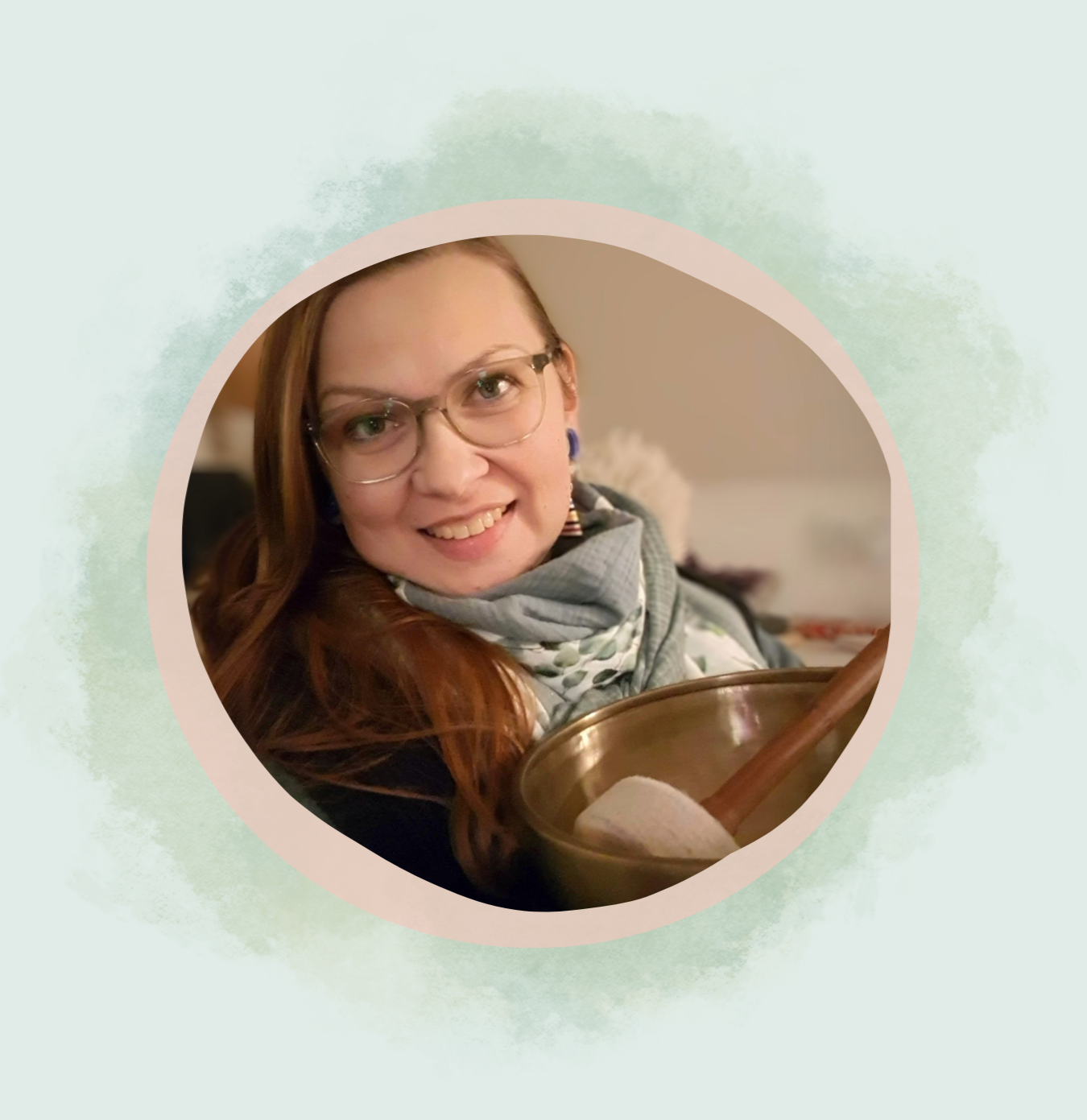 Bild zeigt eine Nahaufnahme von Julia Pantou, mit einer Klangschale auf einer Hand.