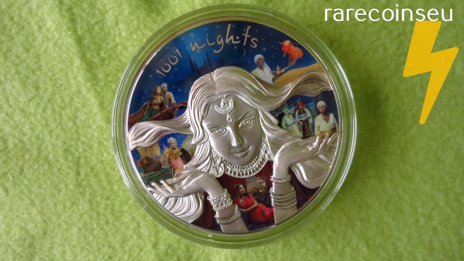 Close-up of a colorful commemorative coin with illustrated faces and “100 nights” text on a green background