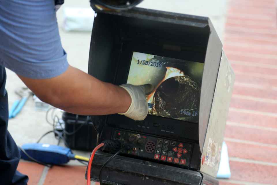 a man using video inspection camera to clear drains