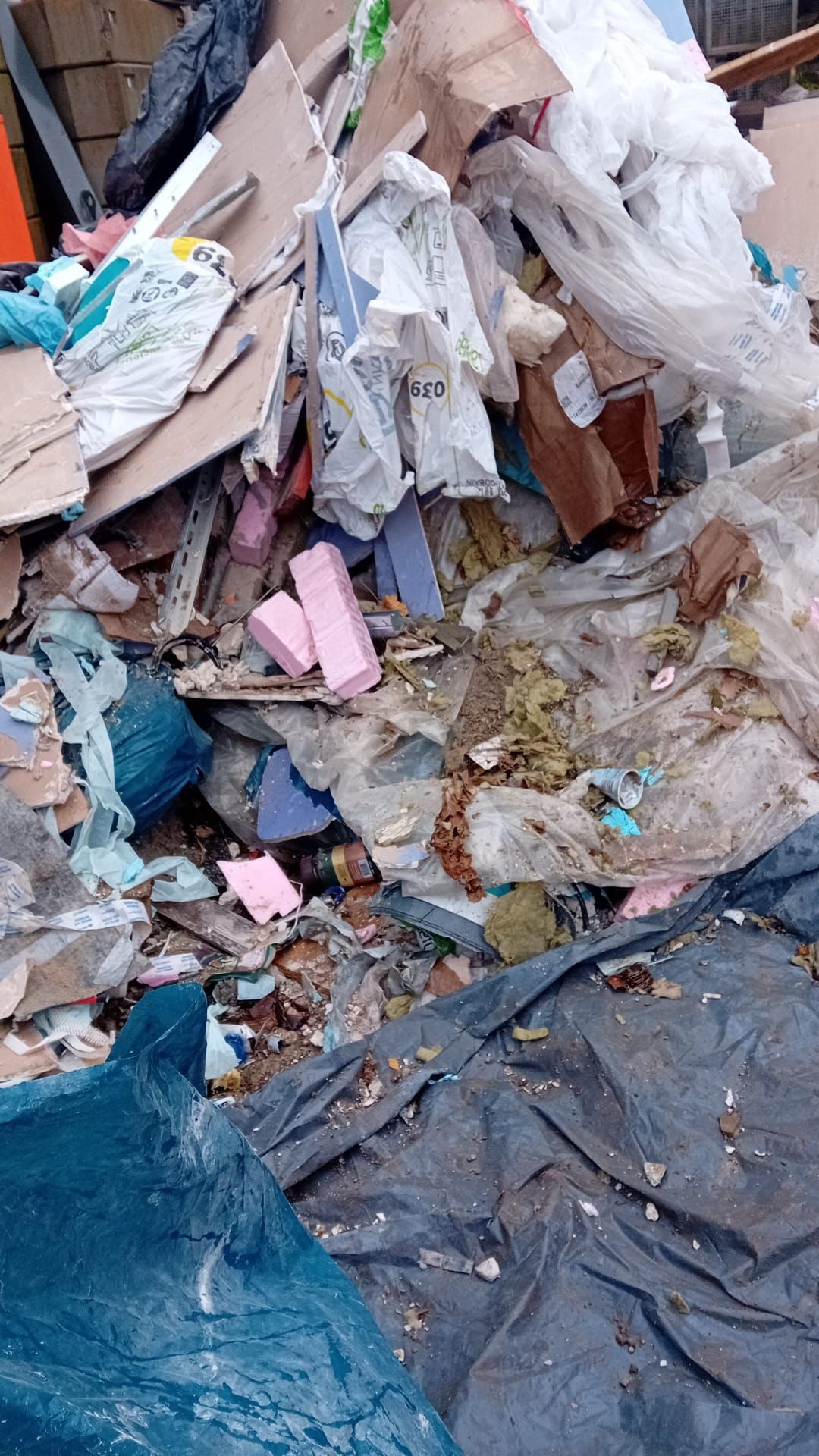 Haufen von Bauschutt und Müll, darunter Pappe, Plastik und Schaumstoff.