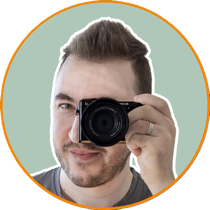 Porträt von Fotograf Jonathan aus Lohmar, mit Sony Kamera, Viltrox Objektiv und freundlichem Blick vor hellem Hintergrund.