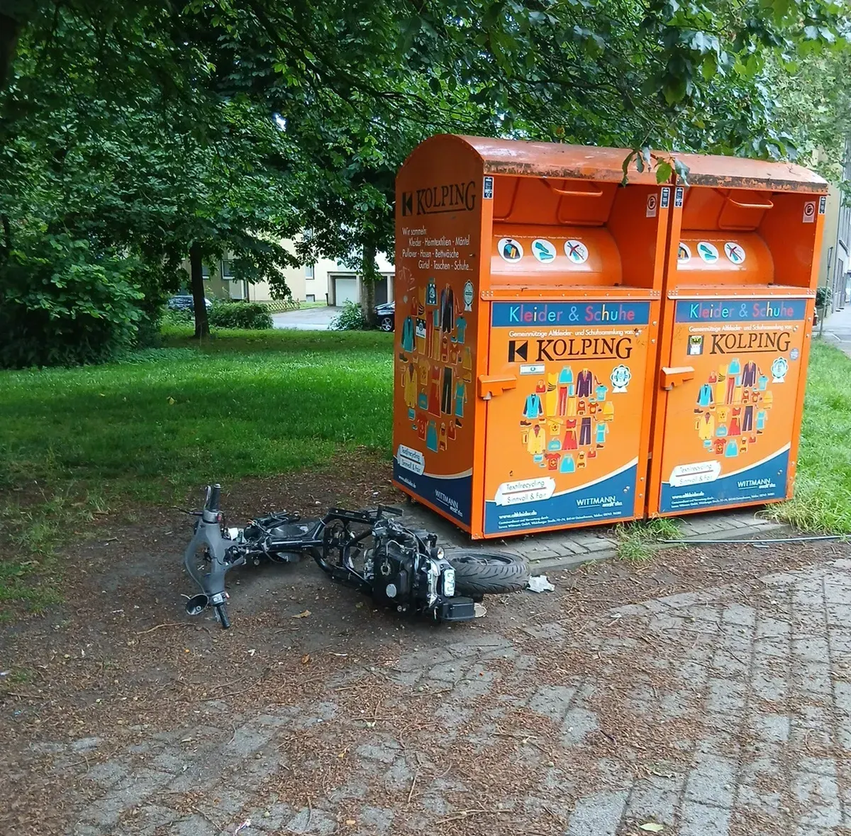Motorradteile neben Altkleidercontainern an der Alleestraße in Duisburg-Hamborn