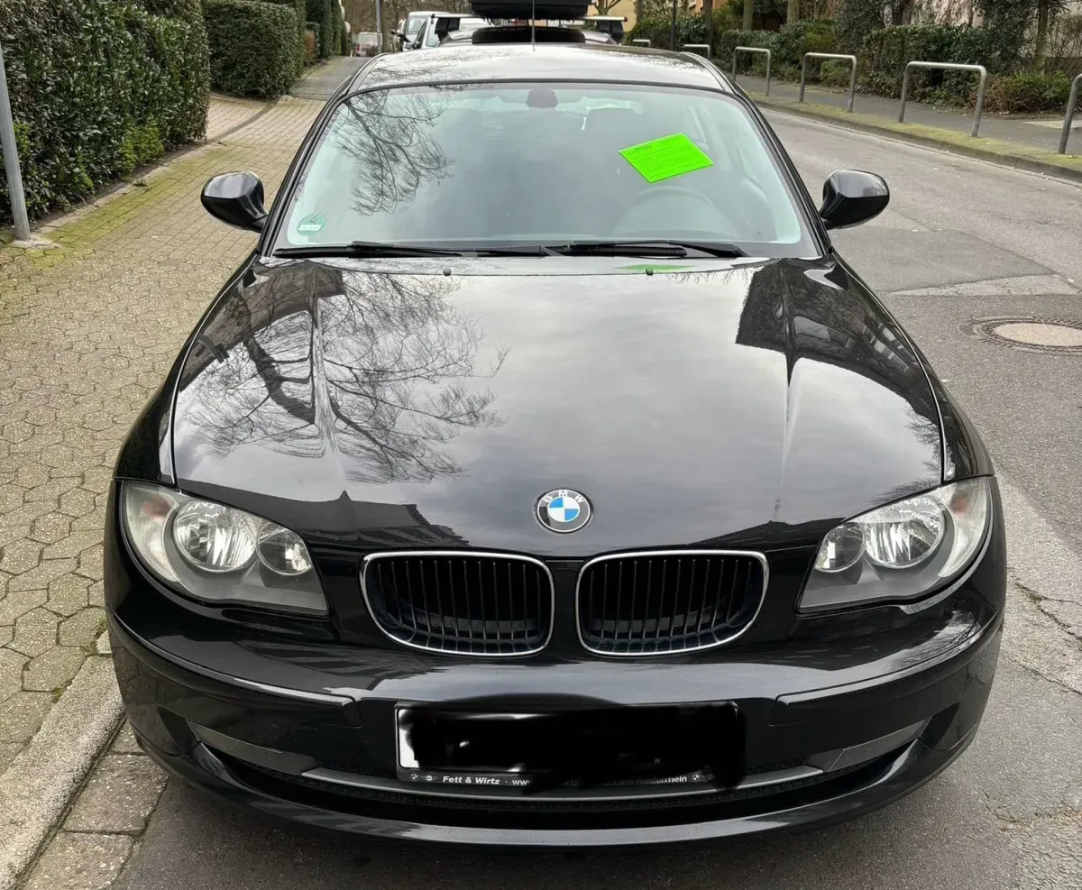 BMW 118i Schwarz Baujahr 2008 - Front mit Beulen und am Scheibe Schrott Kleber Stadt