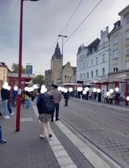 Viele Fahrgäste warten an der DVG‑Haltestelle auf der Duisburger Straße auf die Straßenbahn und füllen den gesamten Bahnsteig.